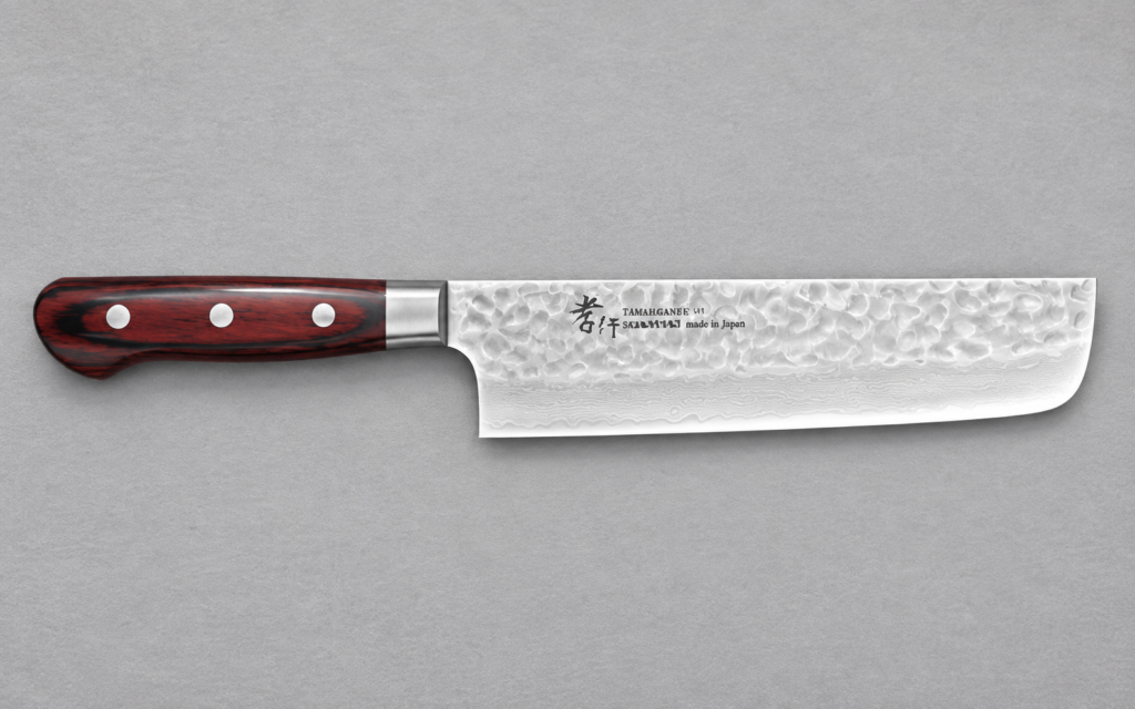 Tamahagane Japanese knife with a hammered blade and reddish wood handle on a dark neutral background