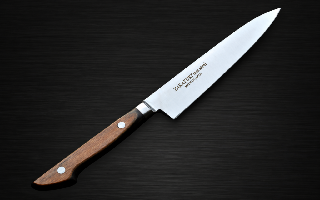 Takayuki stainless steel petty knife with a wooden handle, shown diagonally on a dark black woodgrain background.